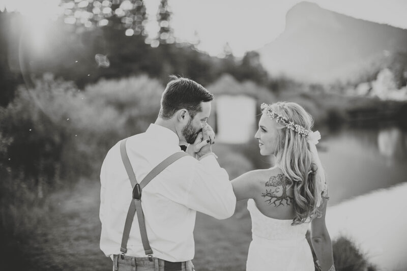 A bride and groom walk together holding hands at sunset wearing a white dress and formal wear for this Lower Lake Ranch wedding photography session