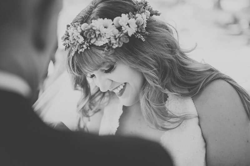 A bride smiling wearing a flower crown and white dress for this Camarillo Ranch wedding photography session