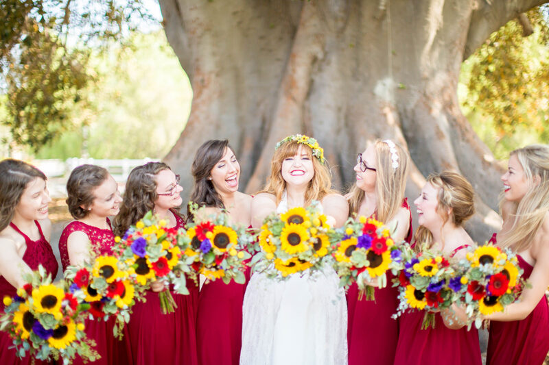 A bride holding her bouquet with her bridesmaids wearing a white dress for this Camarillo Ranch wedding photography session