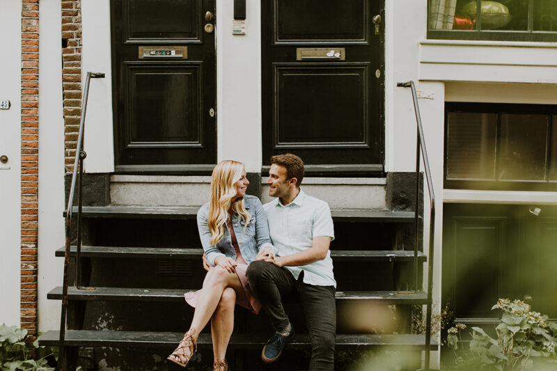 A couple sit on stairs of a neighborhood for this Amsterdam couples photography session