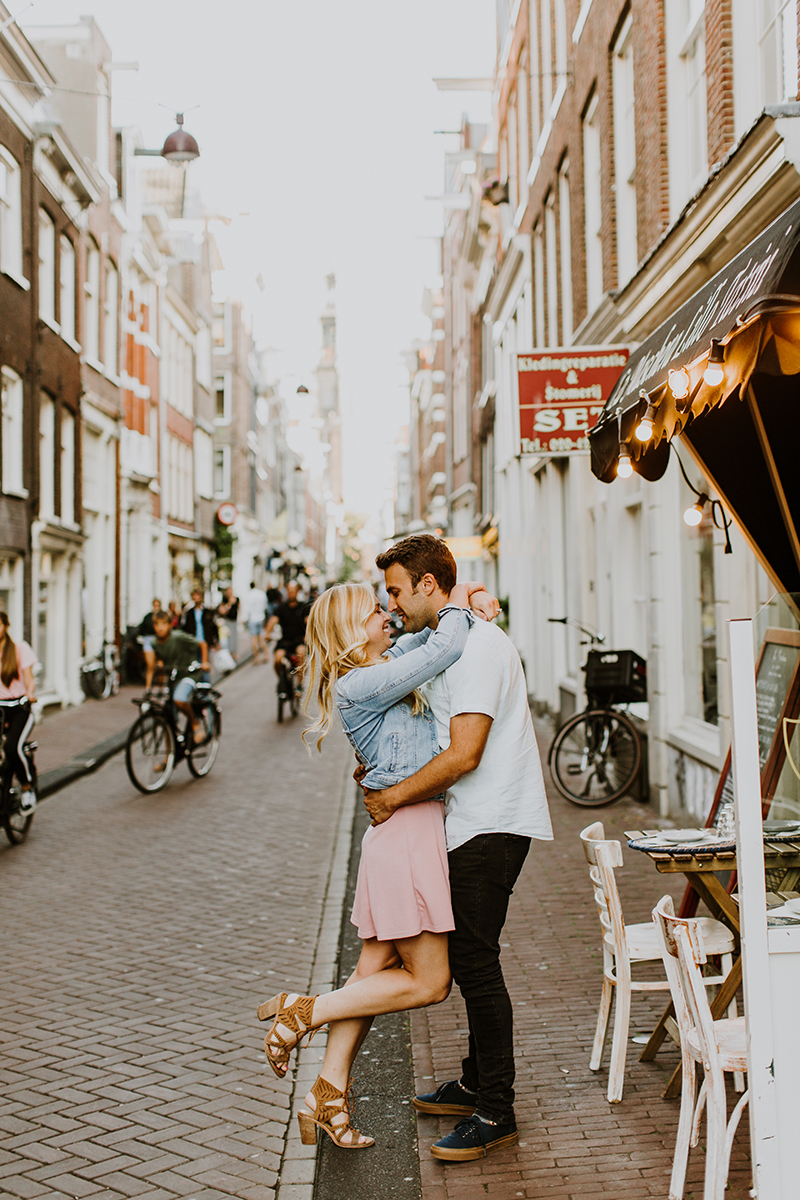 A couple hold one another close in a cute neighborhood for this Amsterdam couples photography session