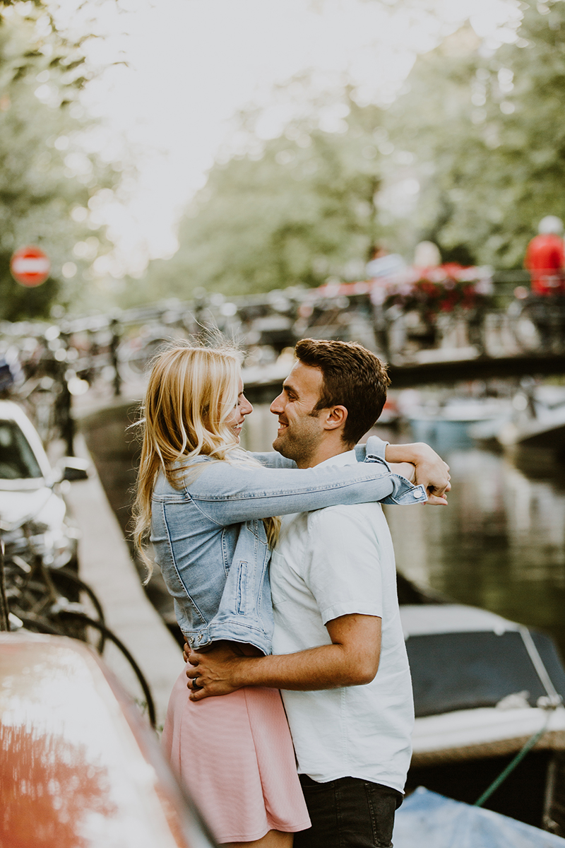 A couple hold one another on the edge of a canal for this Amsterdam couples photography session