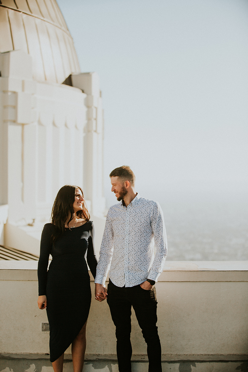 A couple hold each other's hands at the Los Angeles Observatory for this Los Angeles engagement photography session
