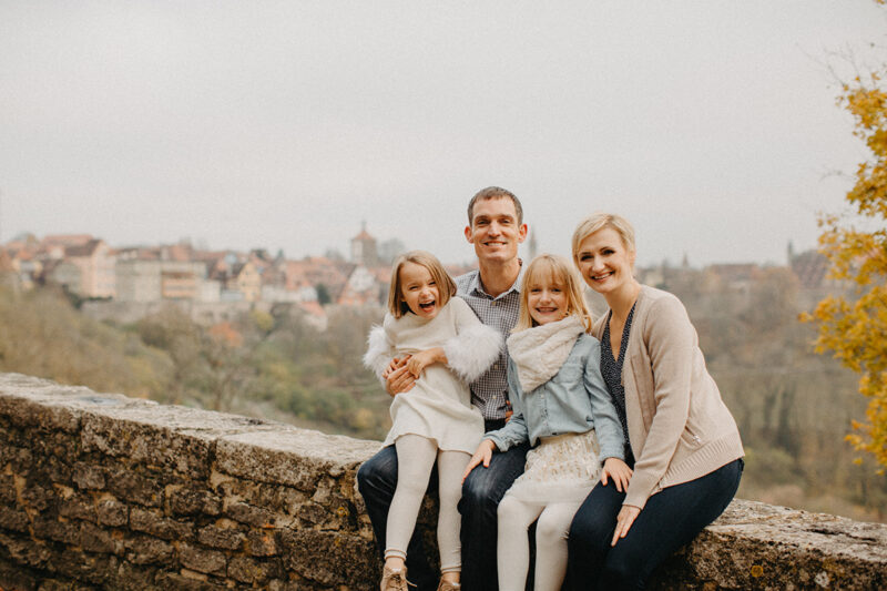A family sits together in Germany wearing coordinated outfits for a Rothenburg ob der Tauber family photography session