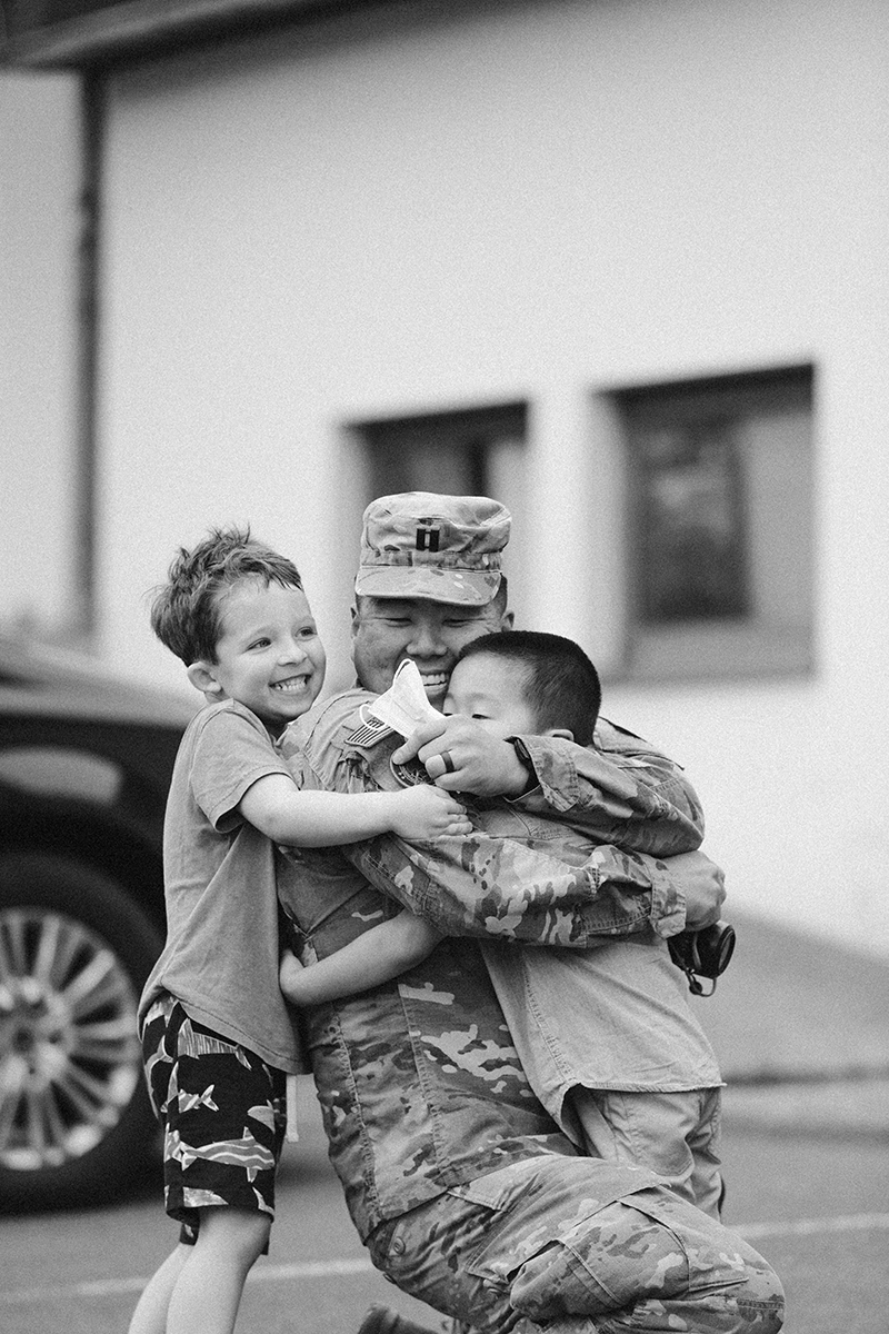 A father hugs his son as they reunite at the Rhineland Ordnance Barracks for Kaiserslautern homecoming photos in Germany