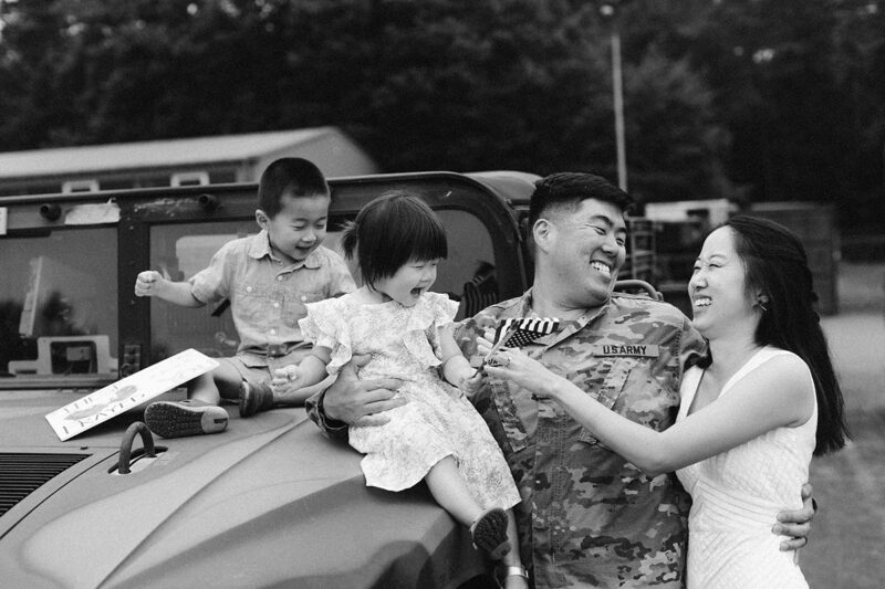 A family hugs one another as they reunite at the Rhineland Ordnance Barracks for Kaiserslautern homecoming photos in Germany