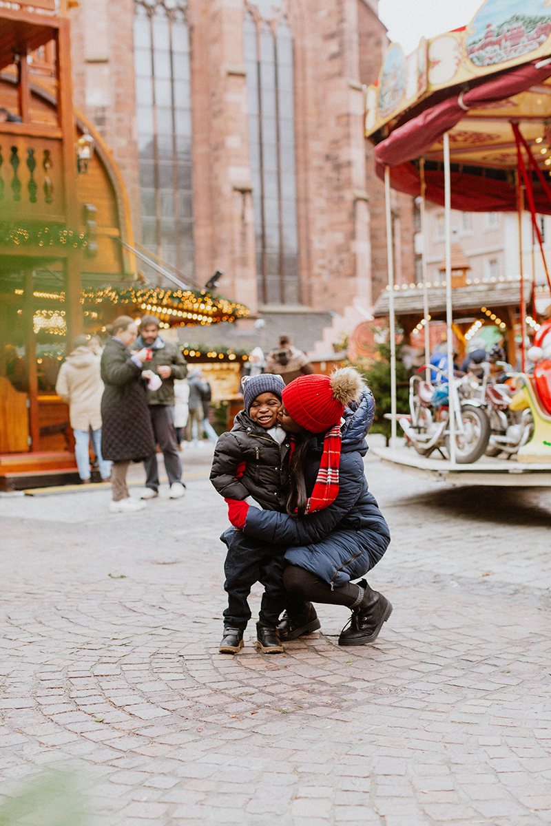 A mother poses with her son for this Heidelberg Christmas market photography mini sessions near Kaiserslautern, Germany