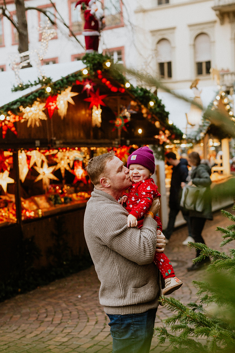 A father poses with his daughter for this Heidelberg Christmas market photography mini sessions near Kaiserslautern, Germany