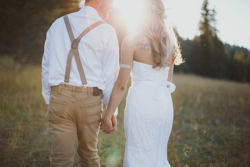 A bride and groom stand together posing at sunset wearing a white dress and formal wear for this Lower Lake Ranch wedding photography session