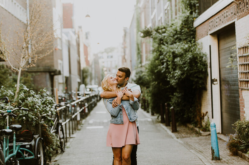 A couple hold one another close in a cute neighborhood for this Amsterdam couples photography session