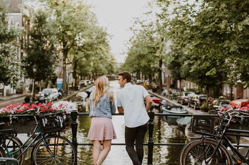 A couple hold one another close on a bridge over a canal for this Amsterdam couples photography sessionA couple hold one another close on a bridge over a canal for this Amsterdam couples photography session