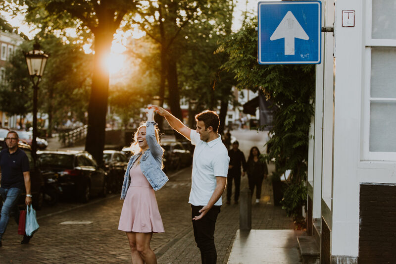A couple dance next to a canal at sunset for this Amsterdam couples photography session