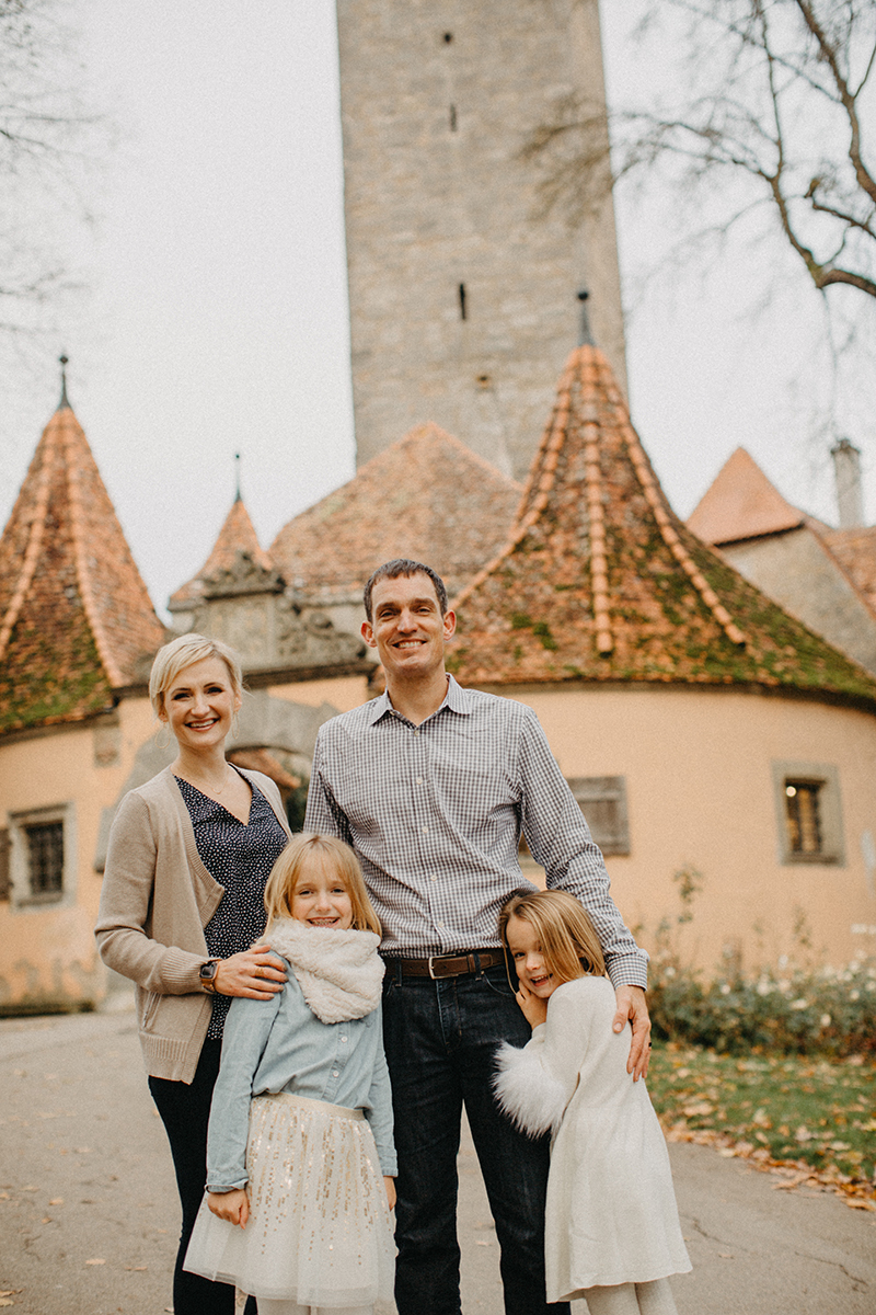 A family stands together in Germany wearing coordinated outfits for a Rothenburg ob der Tauber family photography session
