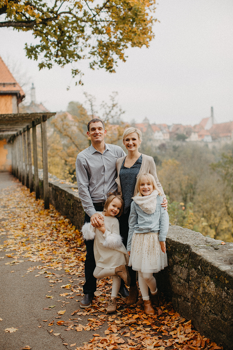 A family stands together in Germany wearing coordinated outfits for a Rothenburg ob der Tauber family photography session