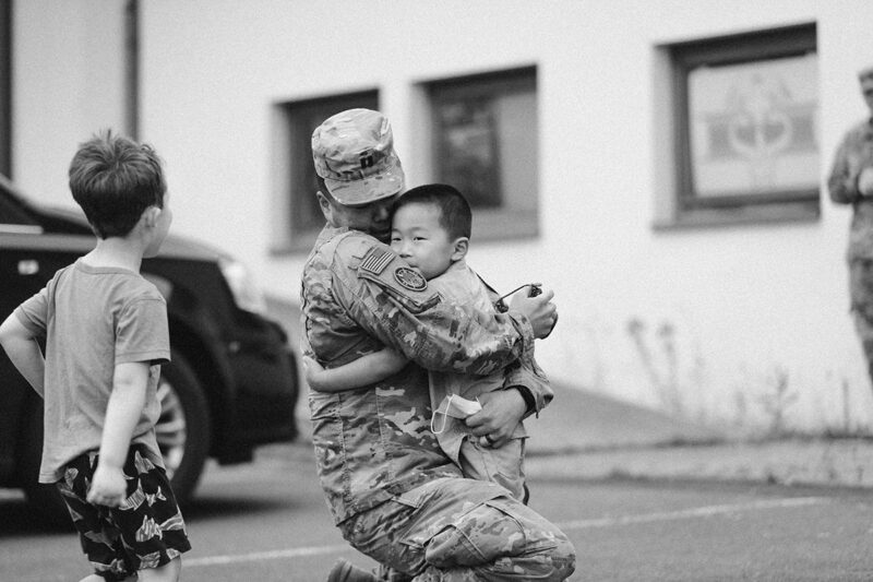 A father hugs his son as they reunite at the Rhineland Ordnance Barracks for Kaiserslautern homecoming photos in Germany