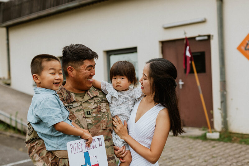 A family hugs one another as they reunite at the Rhineland Ordnance Barracks for Kaiserslautern homecoming photos in Germany