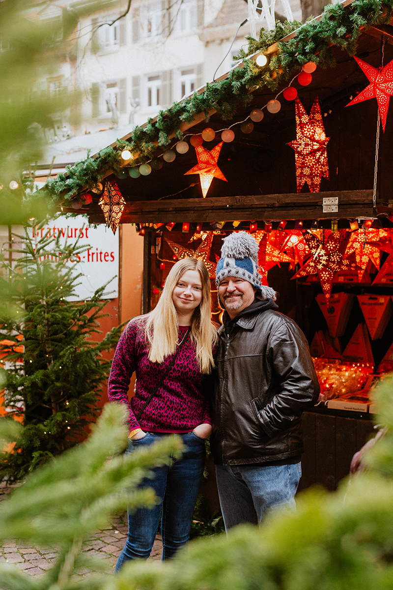 A father poses with his daughter for this Heidelberg Christmas market photography mini sessions near Kaiserslautern, Germany