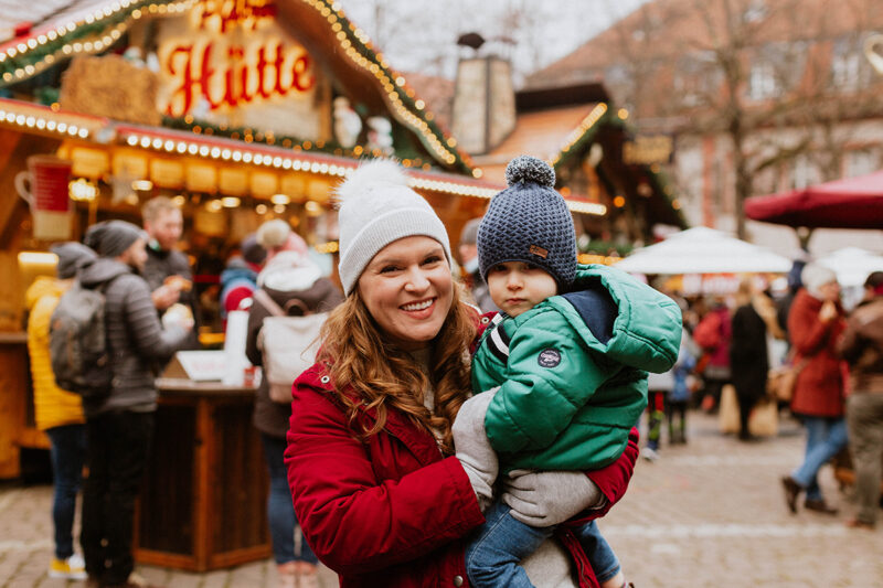 A mother poses with her son for this Heidelberg Christmas market photography mini sessions near Kaiserslautern, Germany