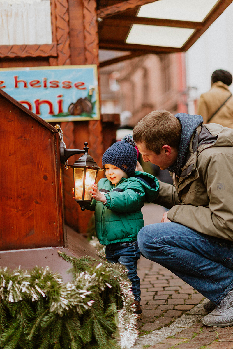 A father poses with his son for this Heidelberg Christmas market photography mini sessions near Kaiserslautern, Germany