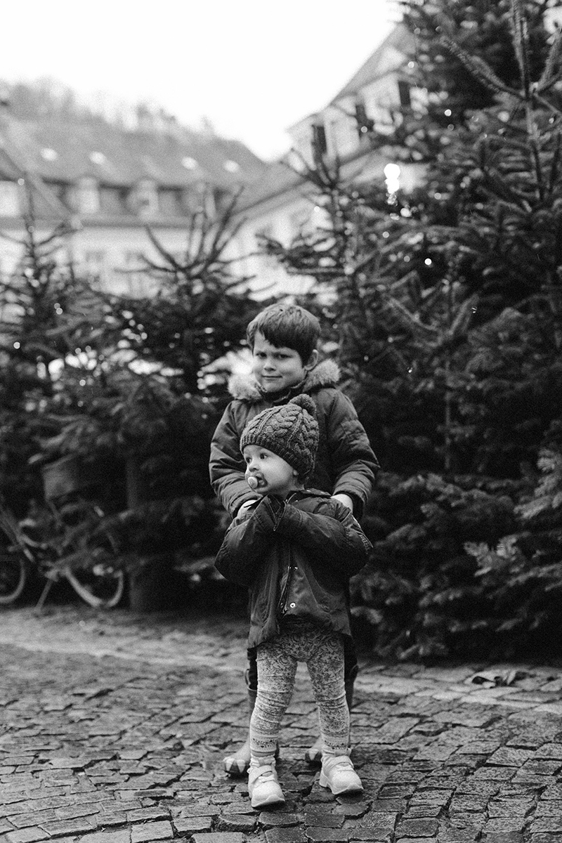 A young boy poses with his sister for this Heidelberg Christmas market photography mini sessions near Kaiserslautern, Germany